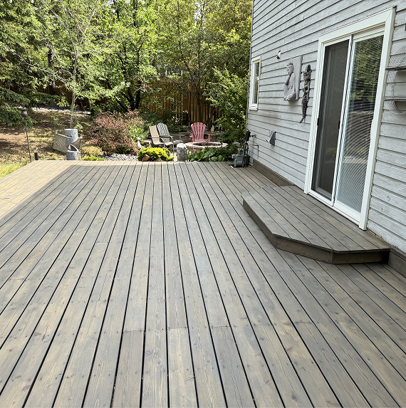Weathered deck and painted home exterior in Chestermere, Alberta — The Birds Stain